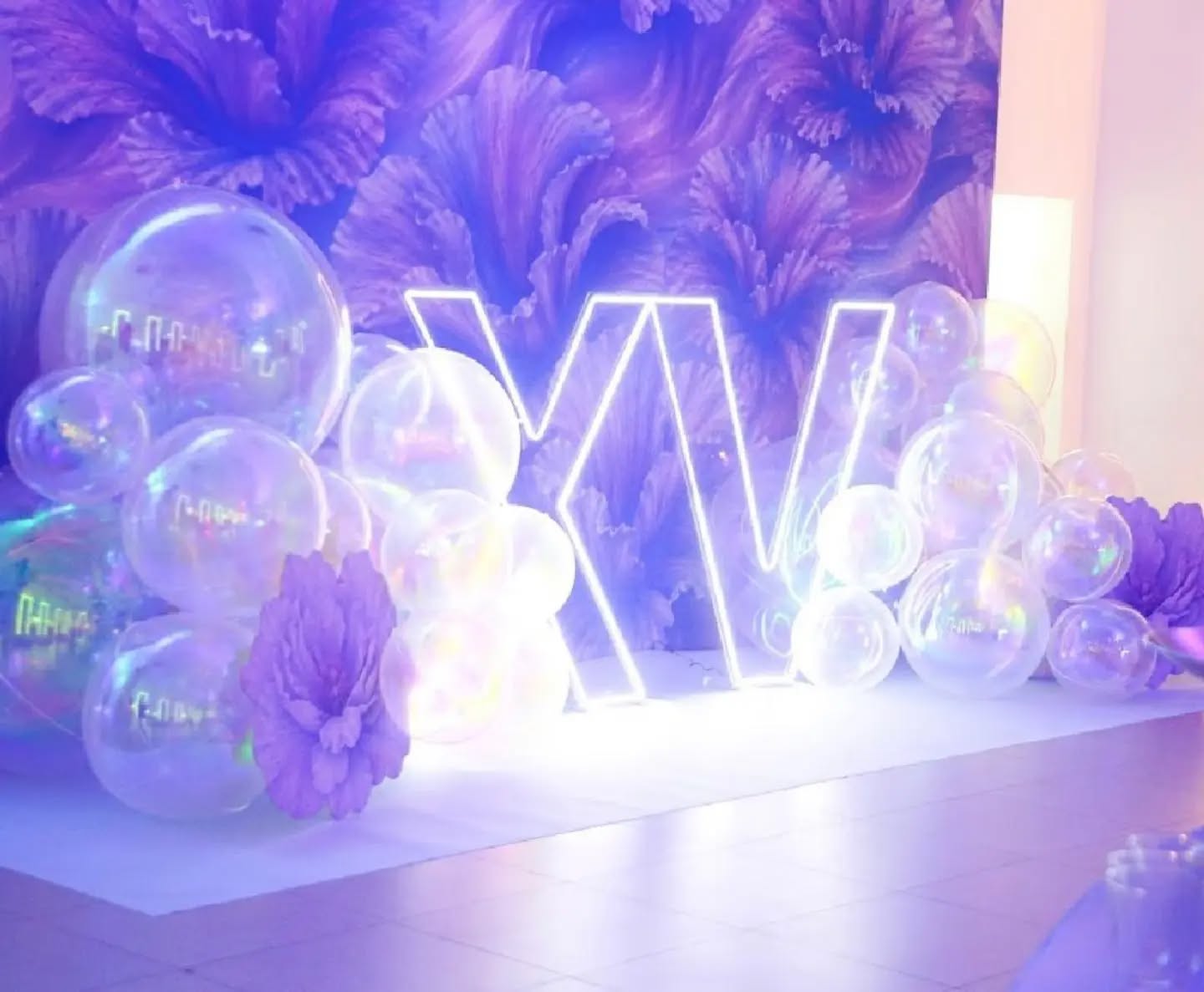 Cenografia iluminada com balões transparentes e tons de violeta