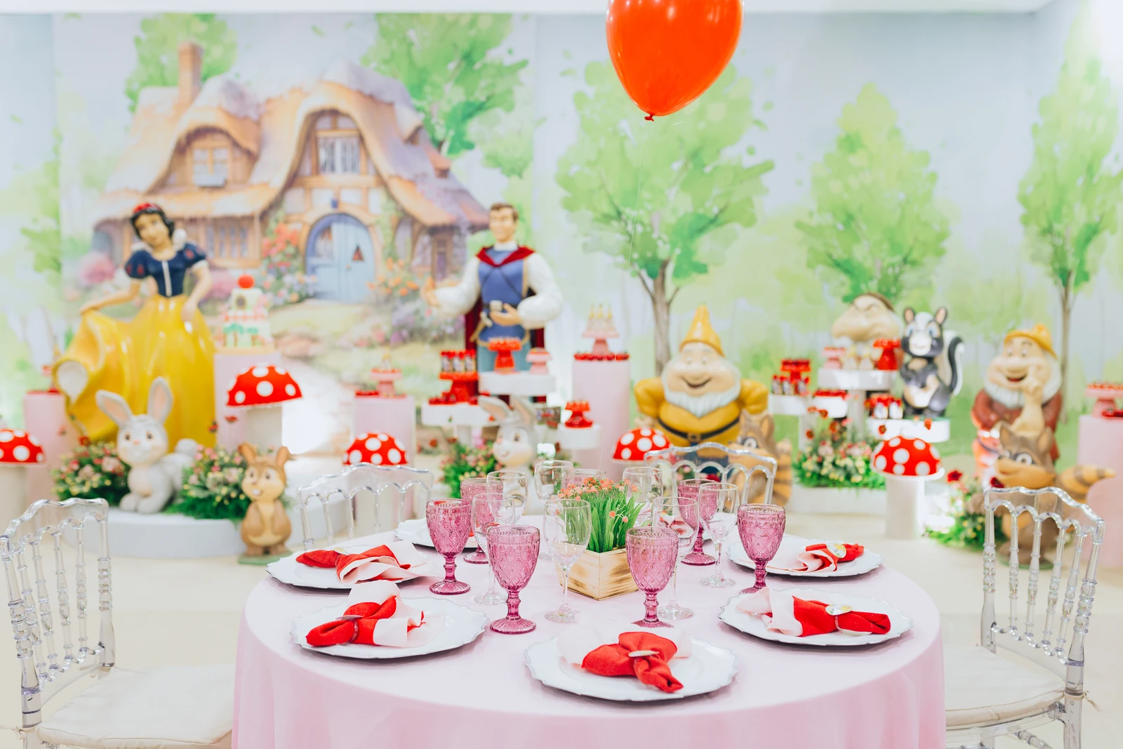Mesas e mobiliário para festa infantil com cenário ao fundo