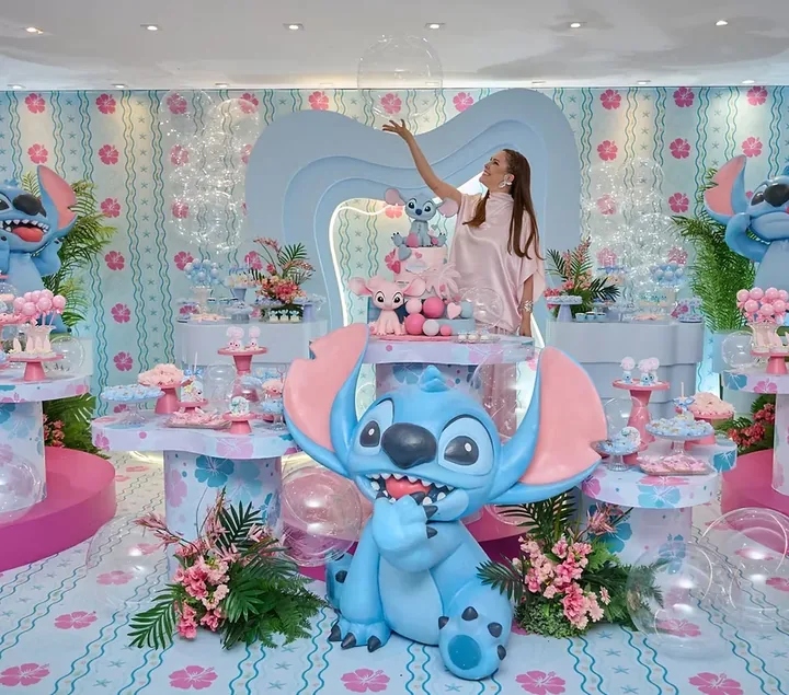 Cenário infantil em tons de azul e rosa com personagens, bolo e decoração temática